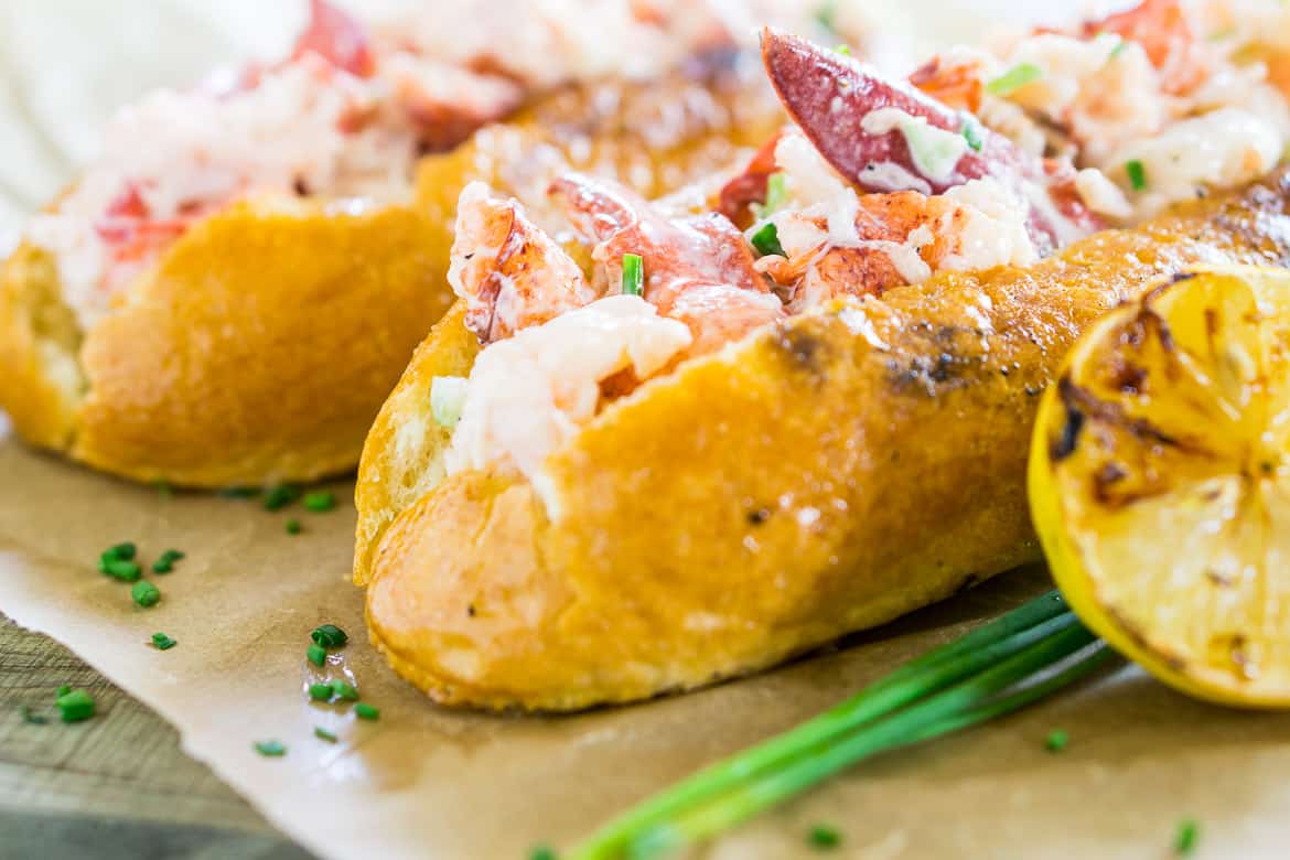 A Maine-style lobster roll on a wood platter.