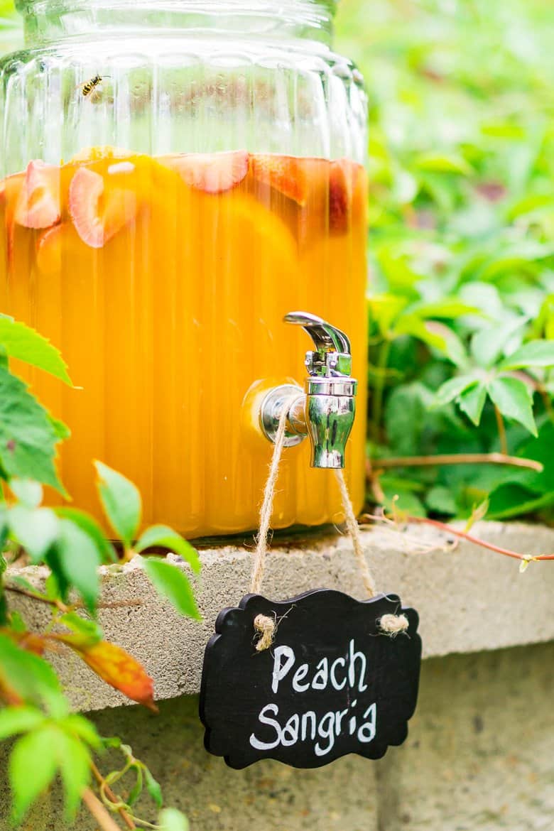 A drink dispenser outside filled with peach sangria.