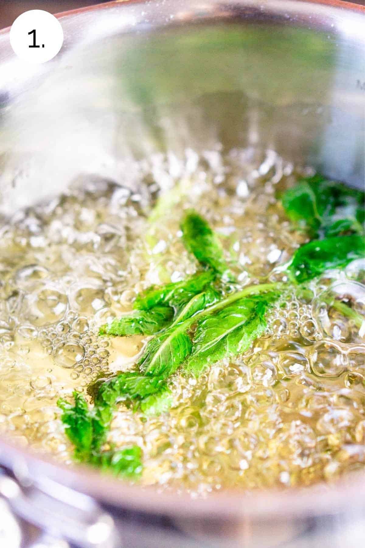 The mint simple syrup boiling in a small saucepan.