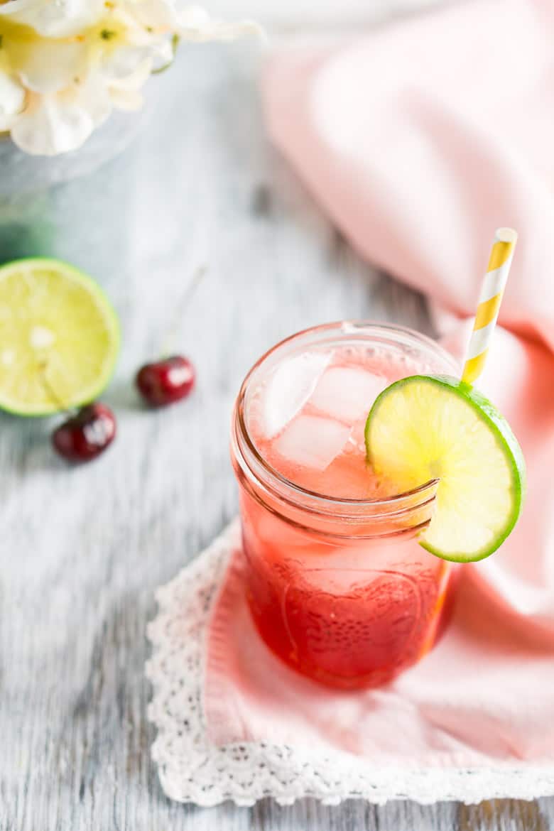 Looking down on the cherry limeade with white flowers to the side.