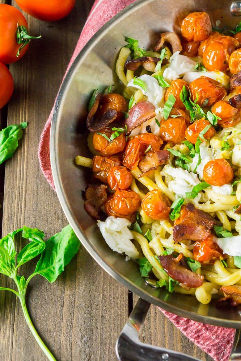 The caprese carbonara in a stainless steel skillet on a red napkin.