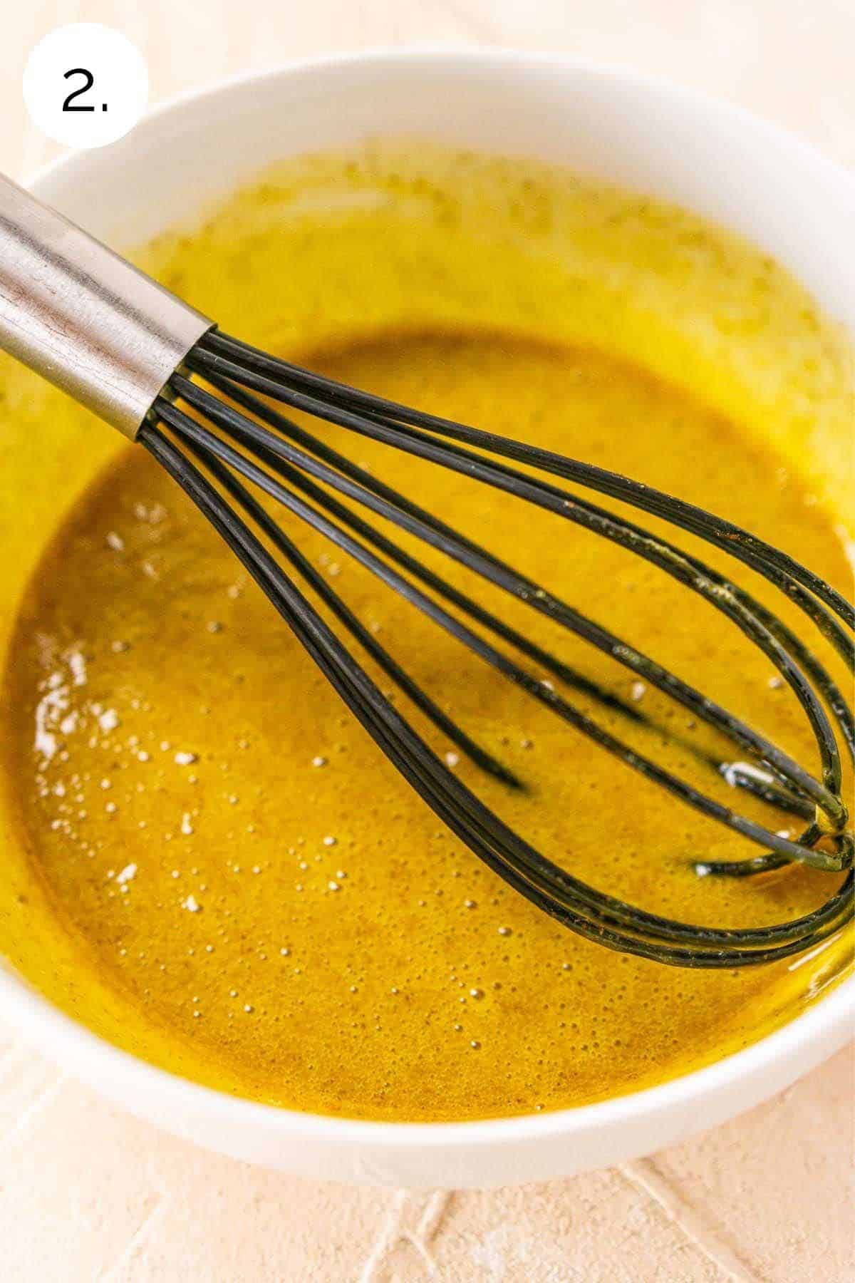Whisking together the egg yolks, pumpkin spice and vanilla in a white small bowl.