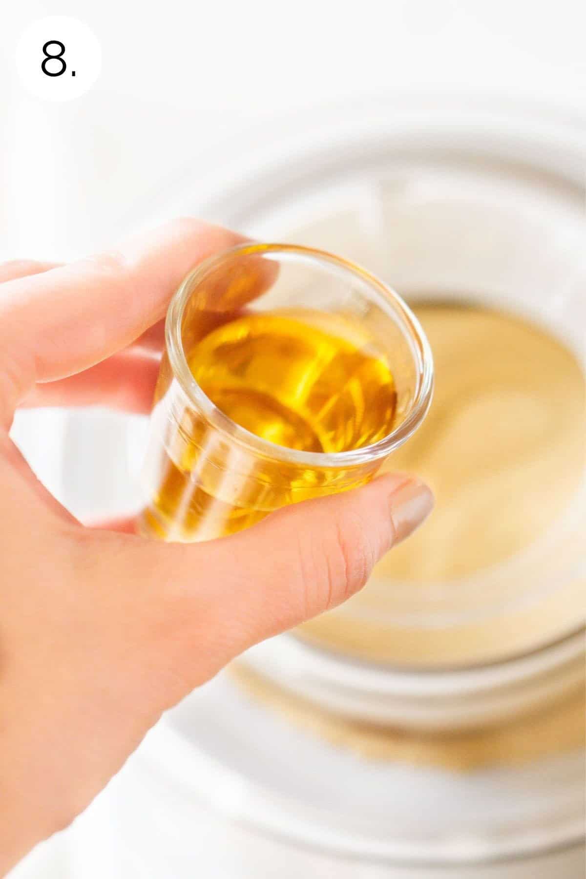 Pouring the bourbon into the churned ice cream.