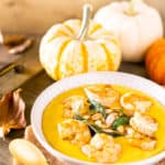 Pumpkin polenta with brown butter shrimp, pumpkin seeds and fried sage with pumpkins and fall leaves as decor.