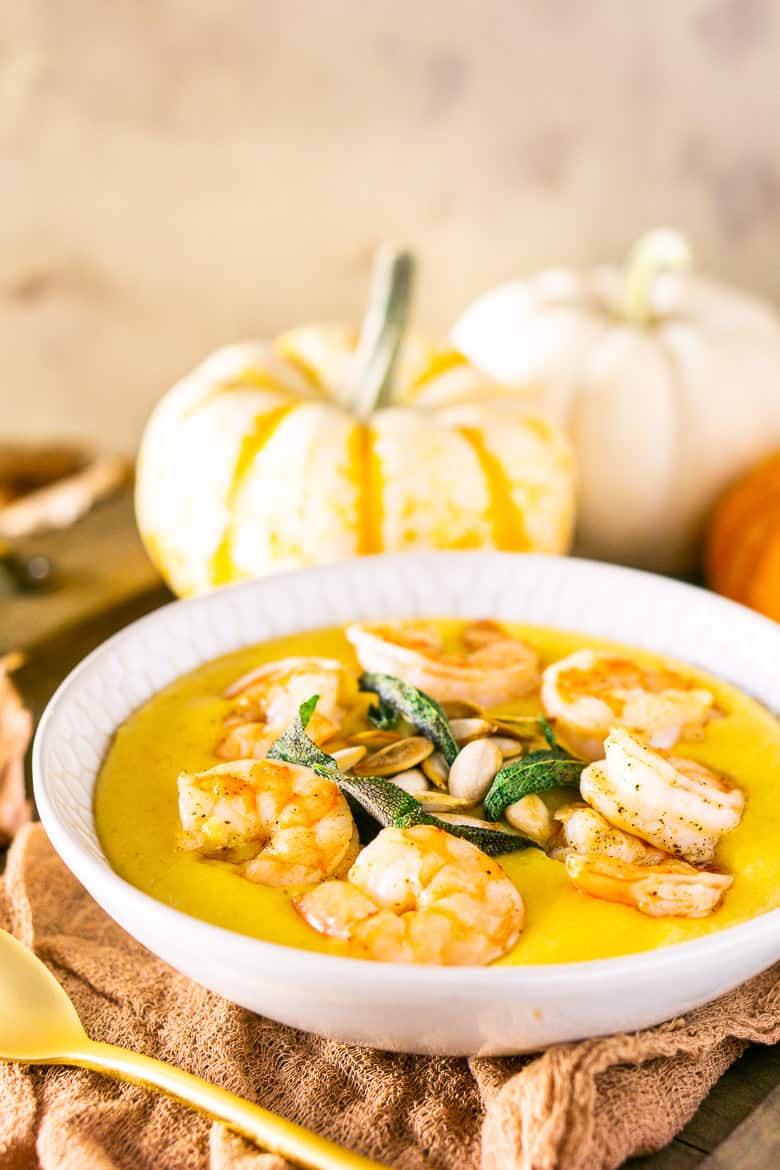 Pumpkin polenta with brown butter shrimp, pumpkin seeds and fried sage with pumpkins and fall leaves as decor.