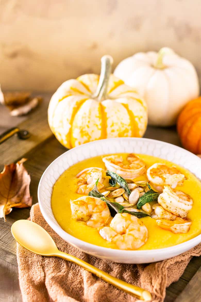 Pumpkin polenta with brown butter shrimp, pumpkin seeds and fried sage with pumpkins and fall leaves as decor.