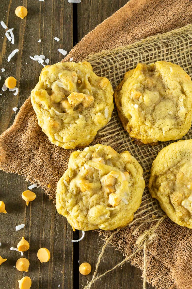 An aerial view of four butterscotch-coconut-bourbon cookies.