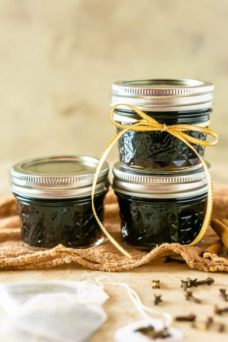 Brown sugar-chai tea simple syrup in mason jars stacked as a pyramid.