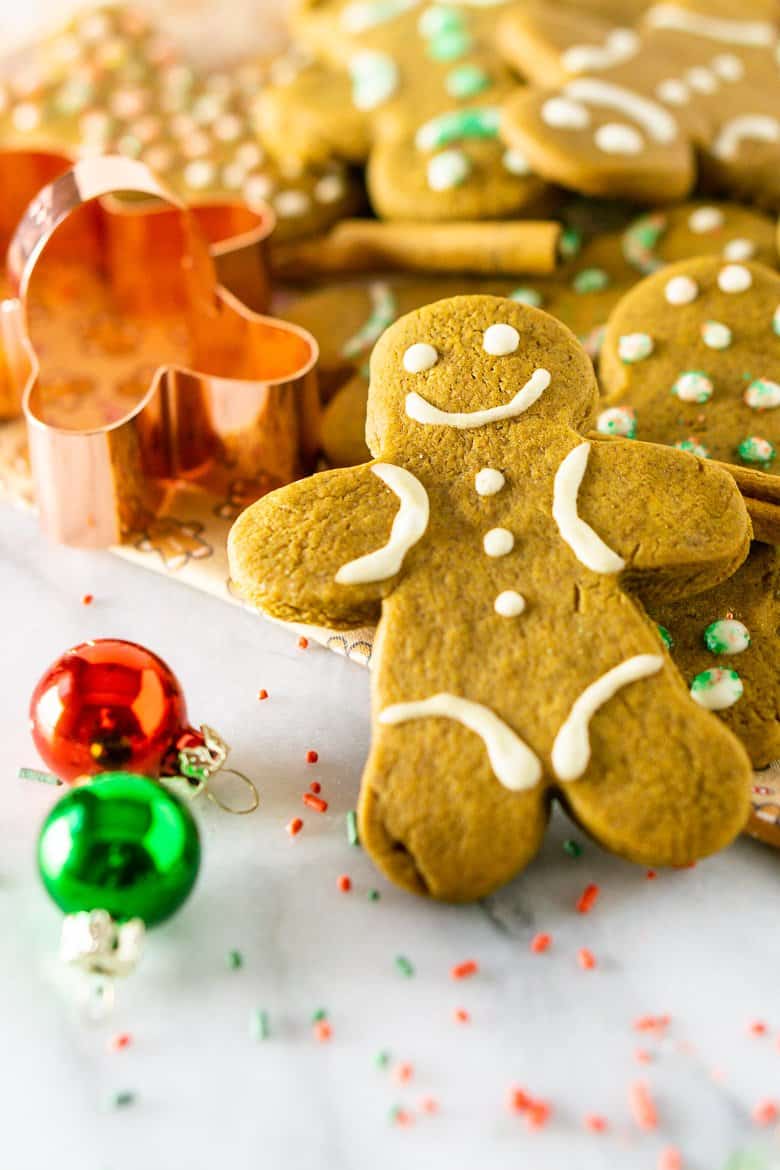 A pile of gingerbread men cookies with a cookie cutter.