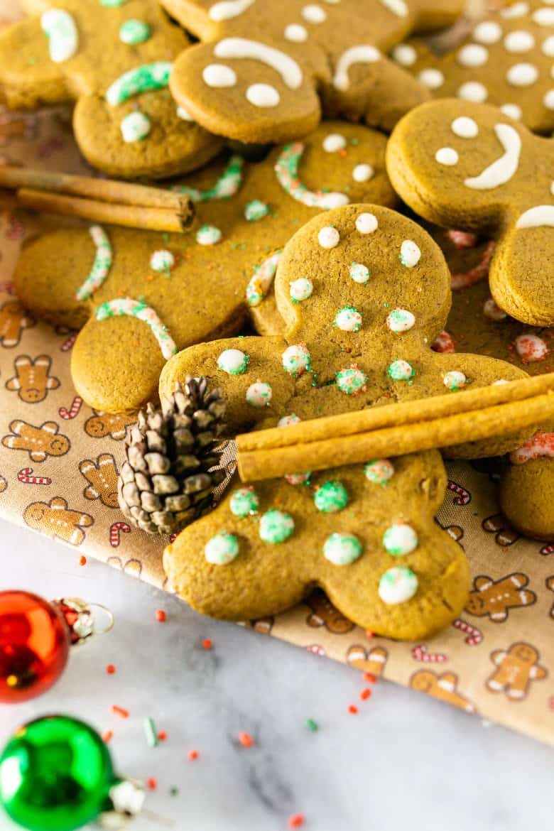 A gingerbread man cookie with a cinnamon stick.