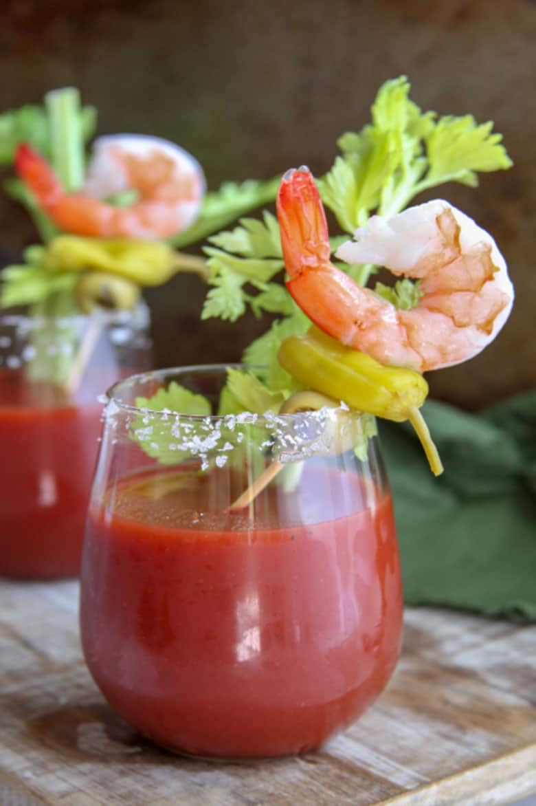 Two bloody Marys garnished with shrimp.