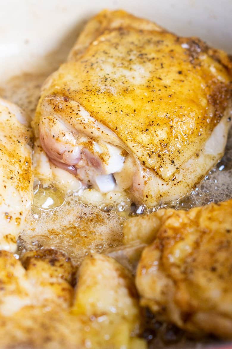 Browning the chicken in a Dutch oven.