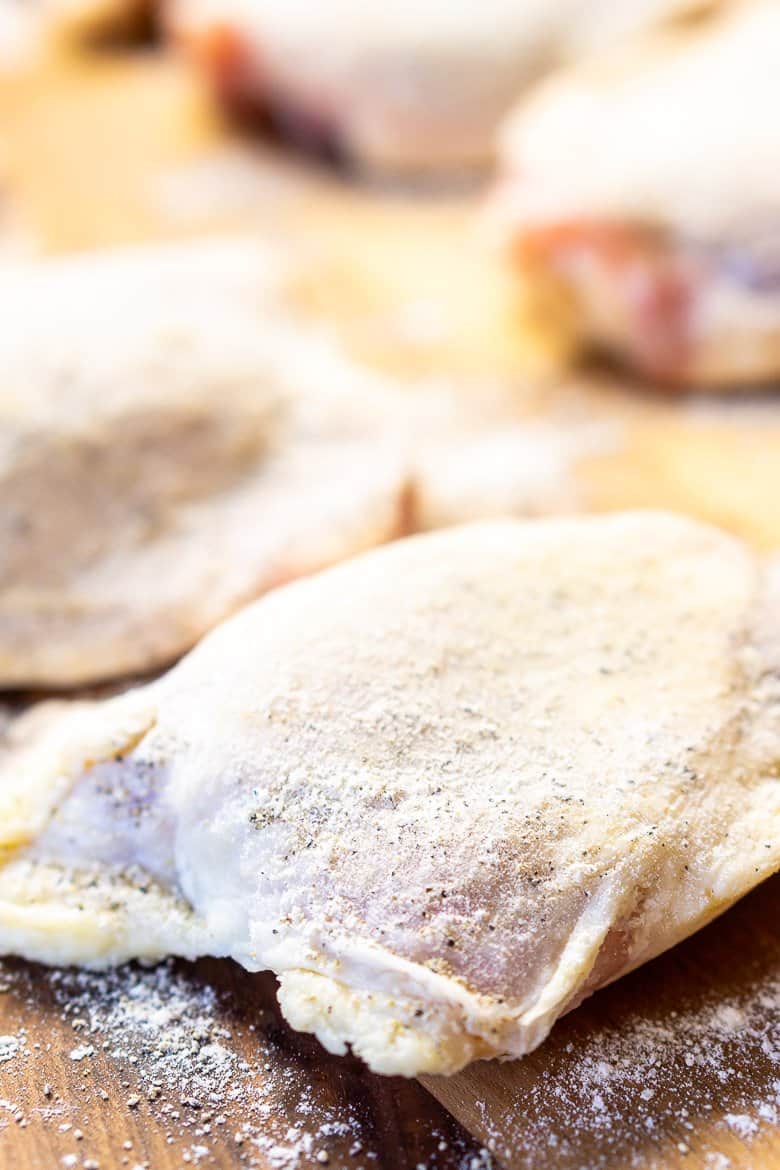 Chicken dusted in flour on a cutting board.