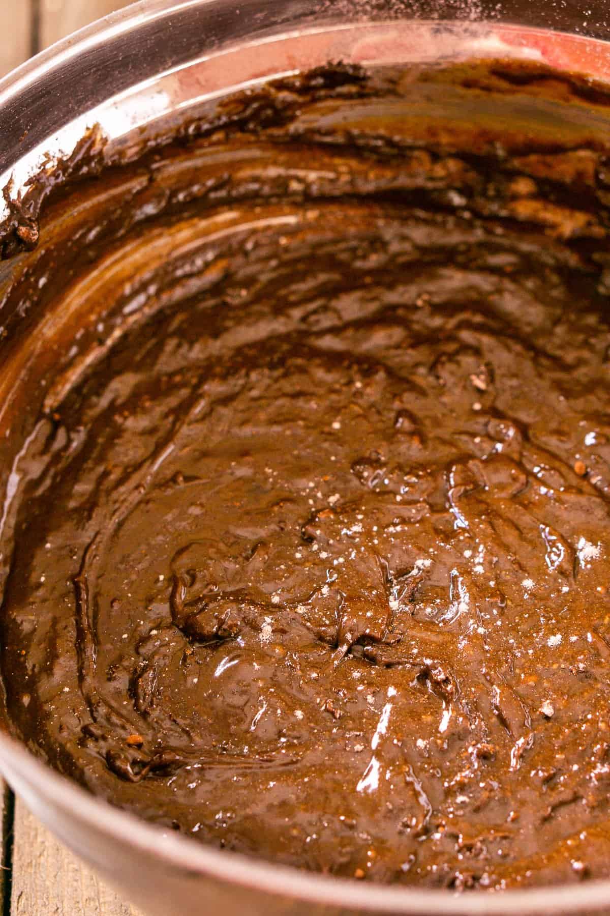 A bowl of fudgy stout brownie batter with just a few flour flakes on top.