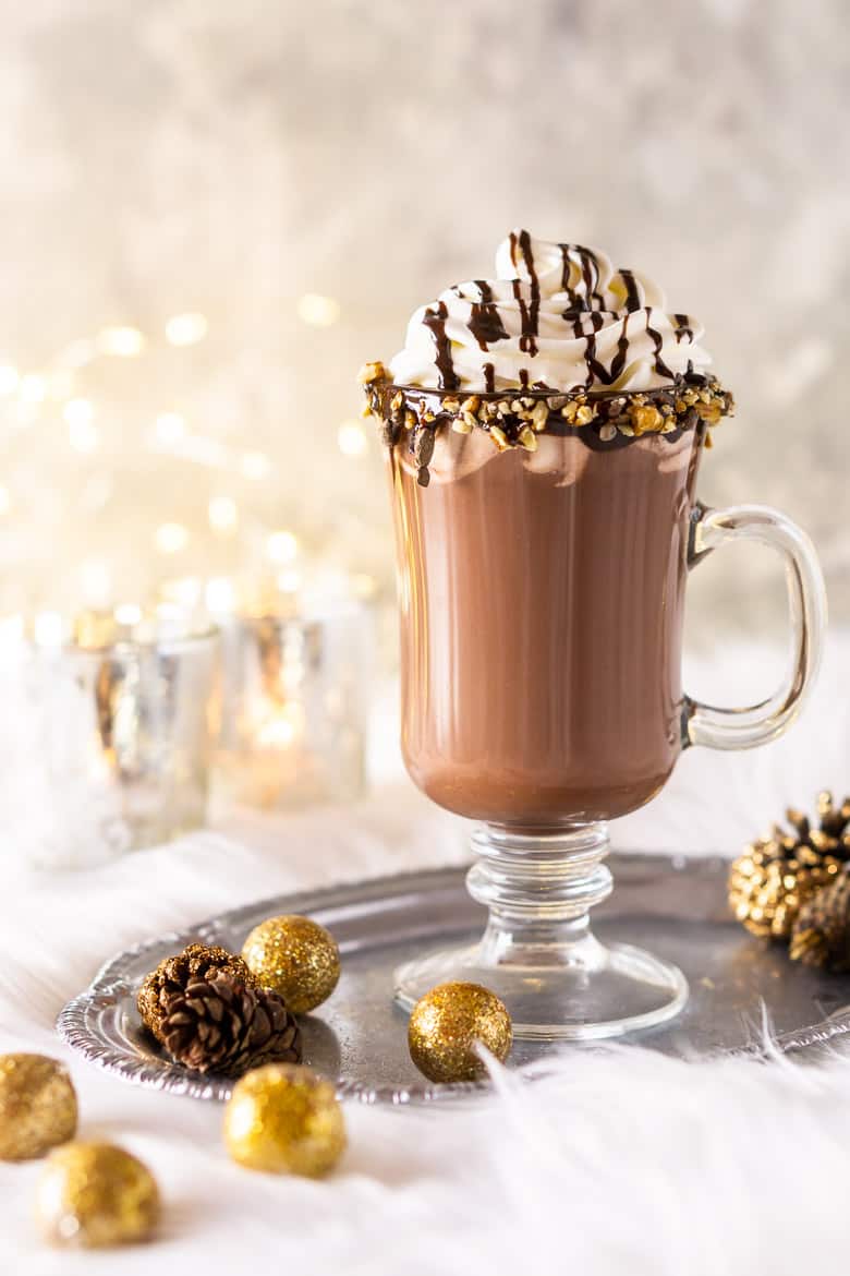 A glass of homemade hot cocoa with candles.