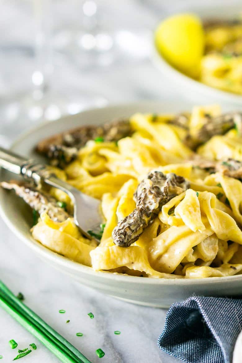 A fork swirling into the morel mushroom pasta.