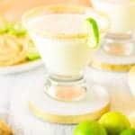 Two sparkling key lime pie martinis with graham crackers and key limes.