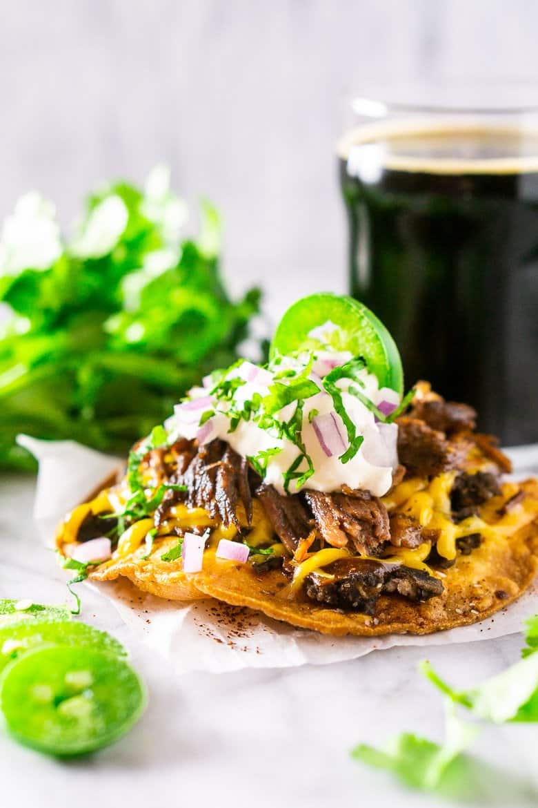 A closeup of the beer-braised Mexican shredded beef on a tostada.