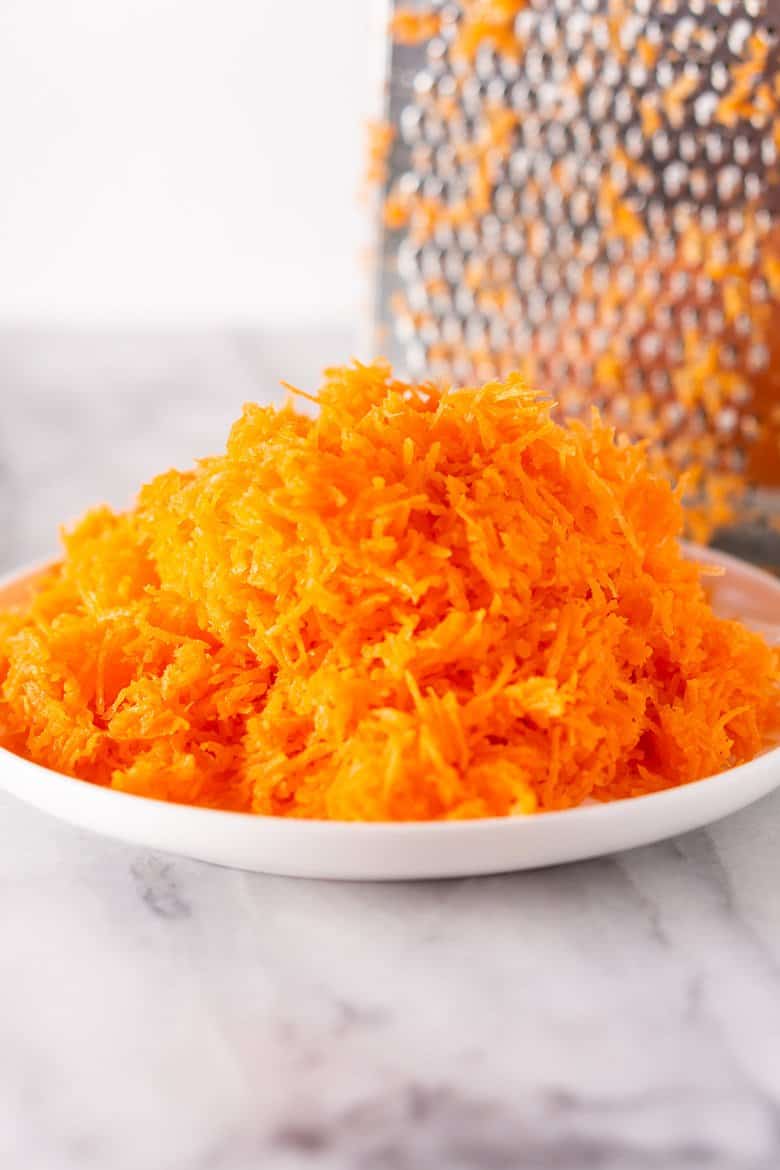 Grated carrot for homemade carrot cake with box grater.