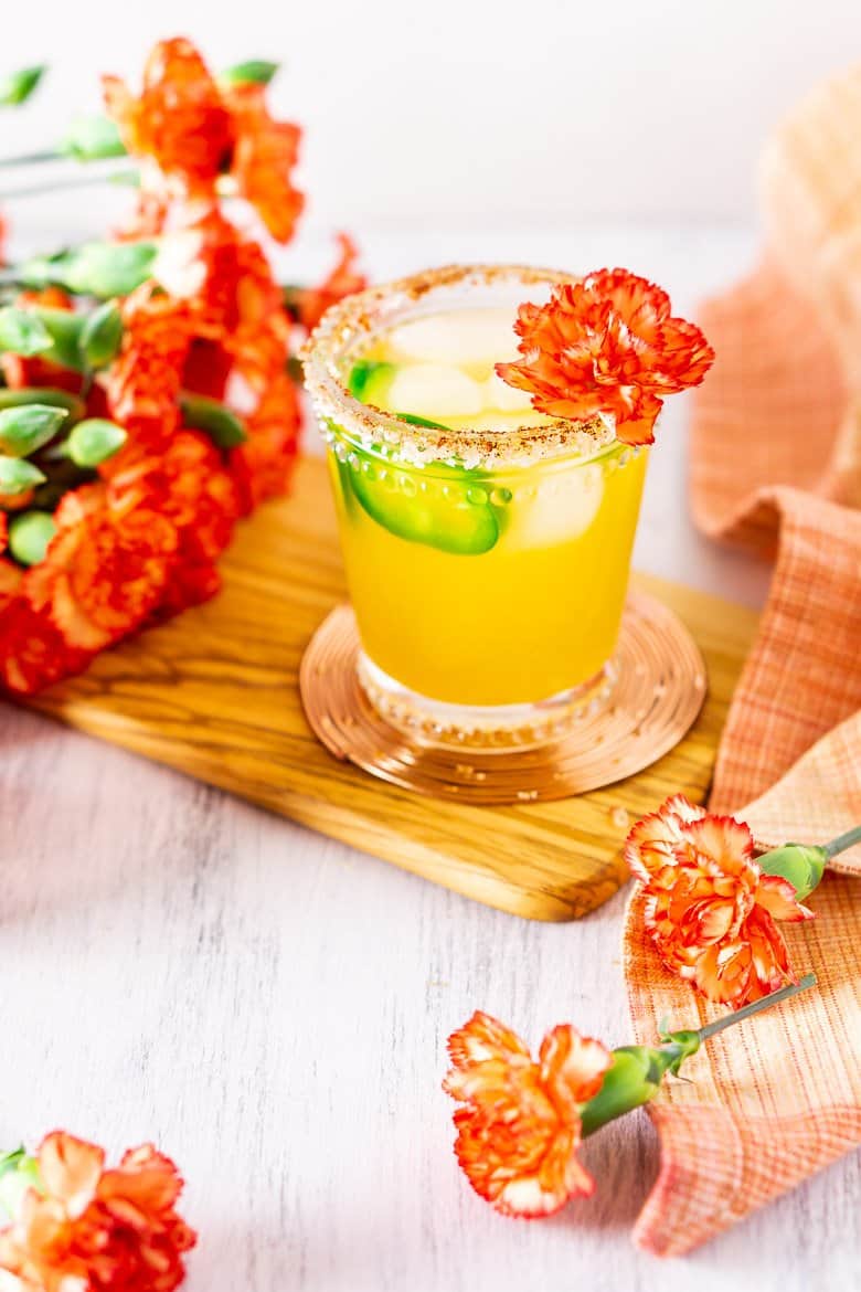 A jalapeno-mango margarita with flowers in the background.