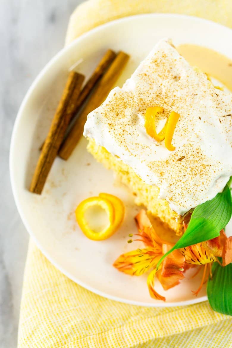 An aerial view of one slice of spiced orange tres leches cake with a flower.