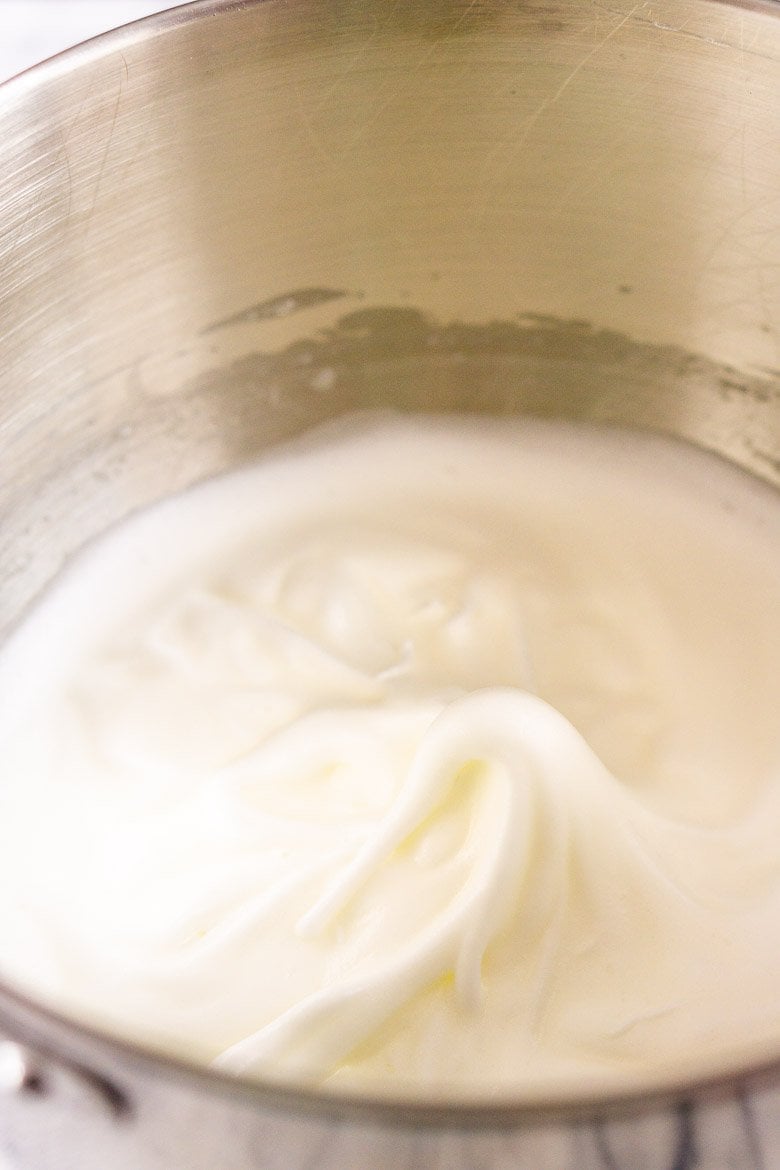 A bowl of egg whites beaten to soft peaks.