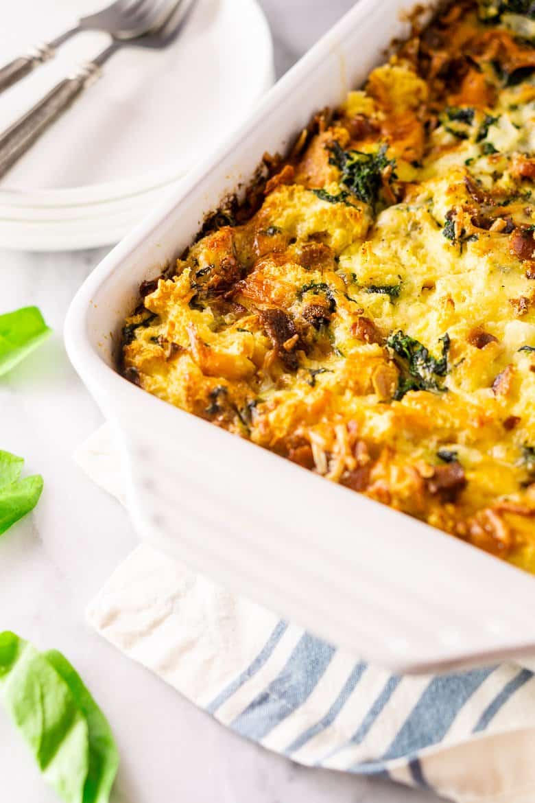 A pan of cooked bacon, Gruyere and spinach strata on a napkin.