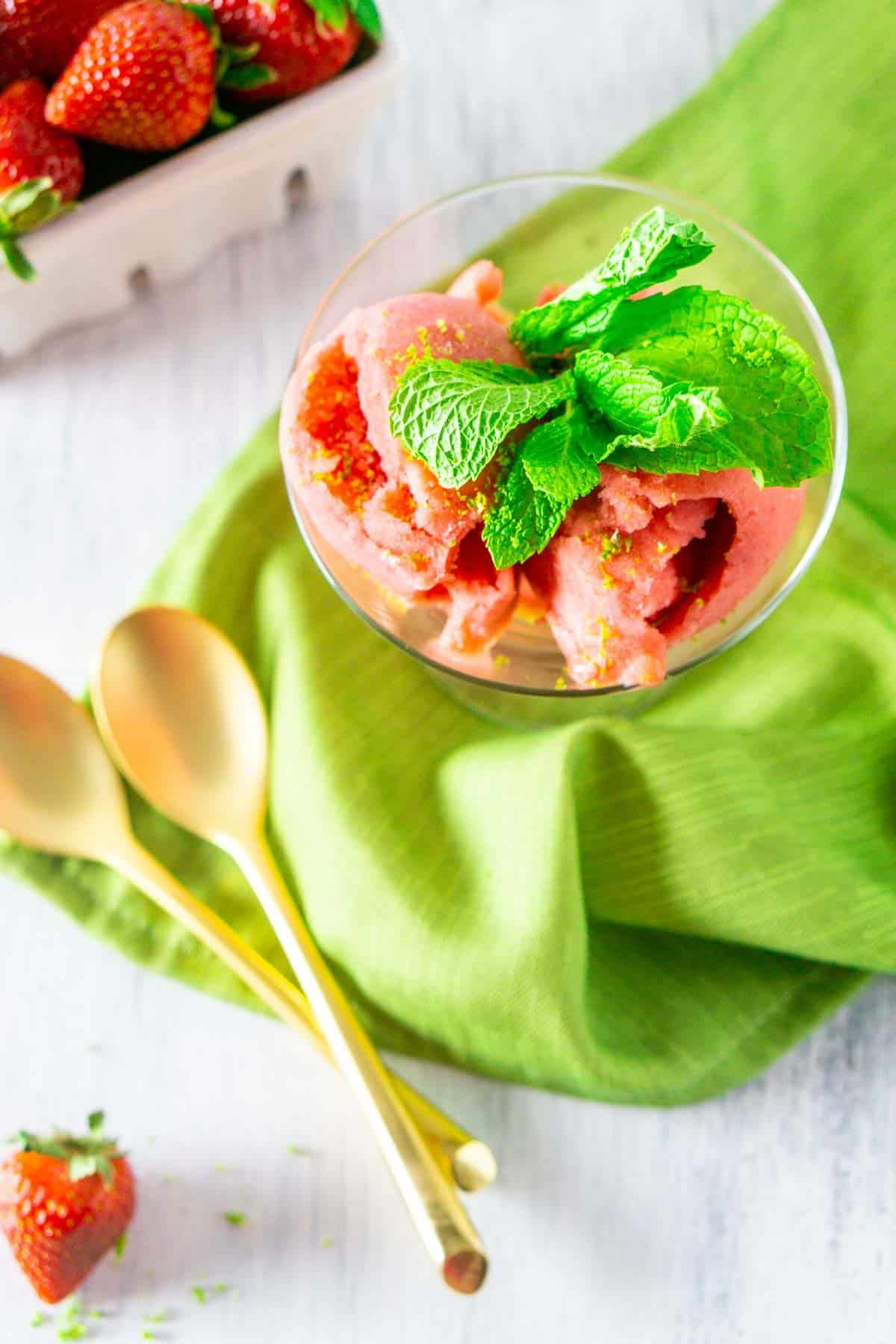 An aerial view of the strawberry mojito sorbet with a strawberry and zest.