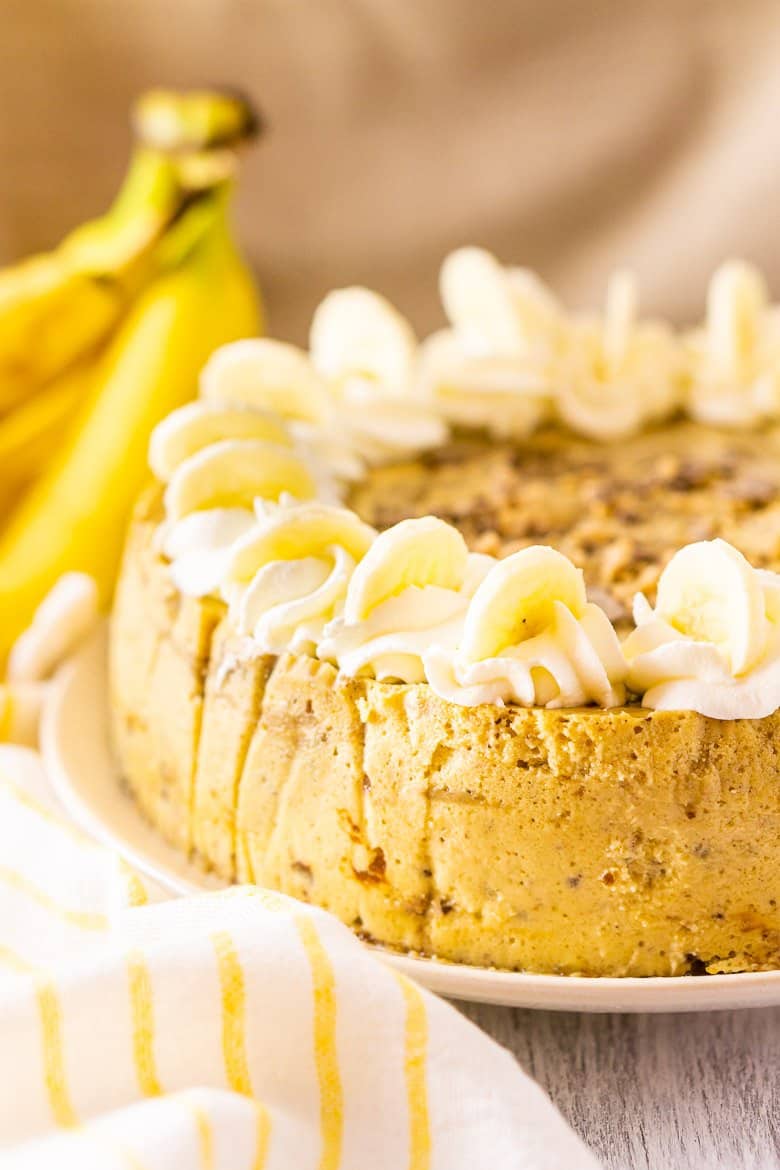 The toffee-bananas foster cheesecake with bananas and a yellow and white napkin.