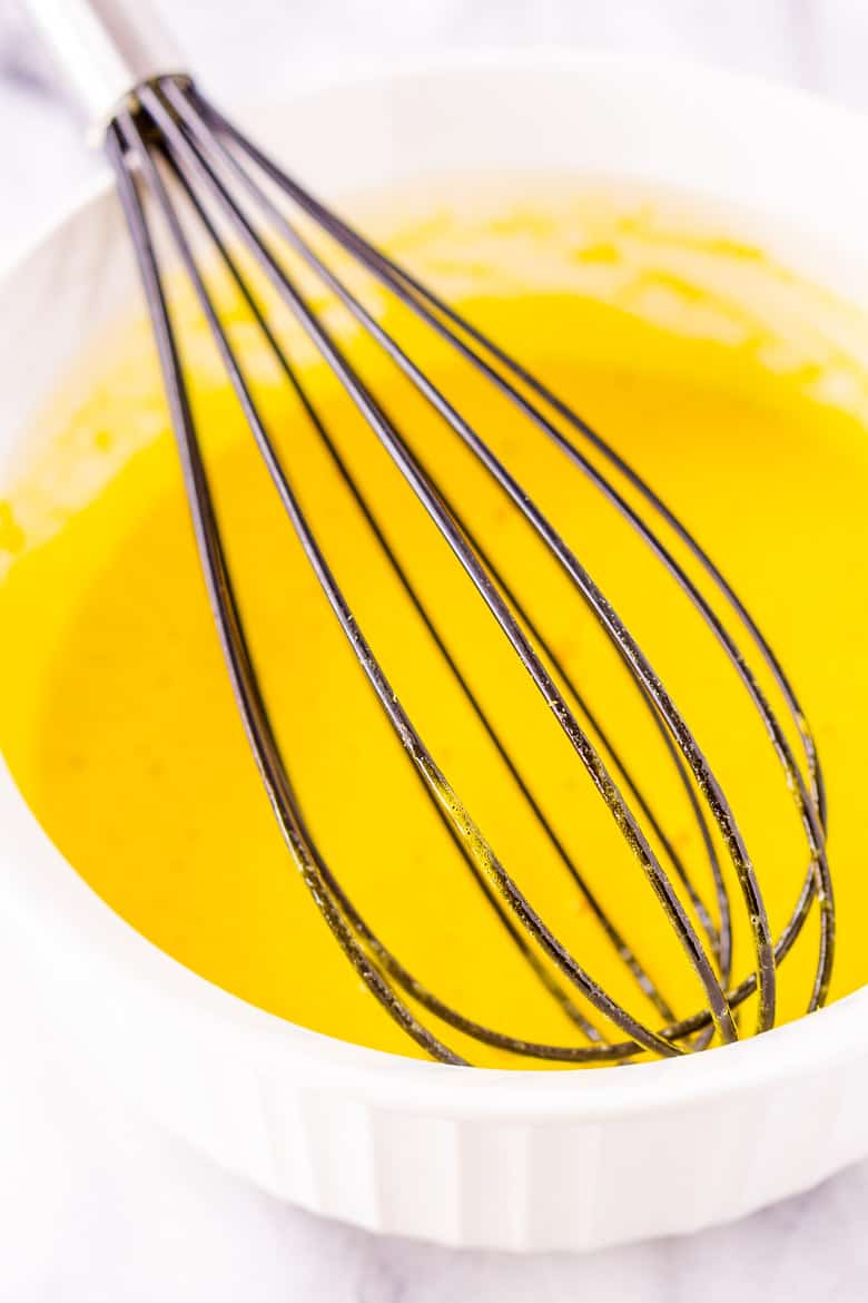 A bowl with egg yolks that were just whisked with vanilla extract.