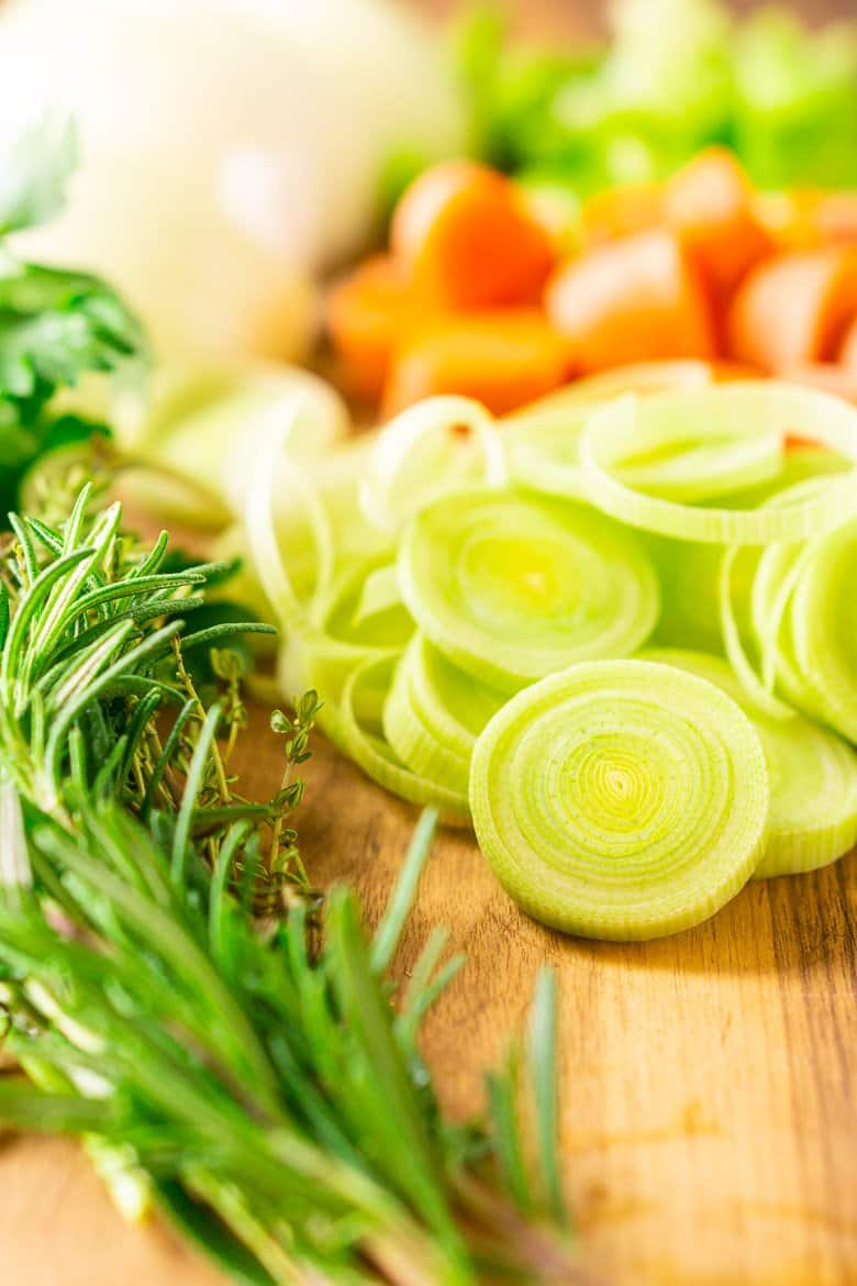 A cutting board with the aromatics used for cooking this homemade seafood stock.