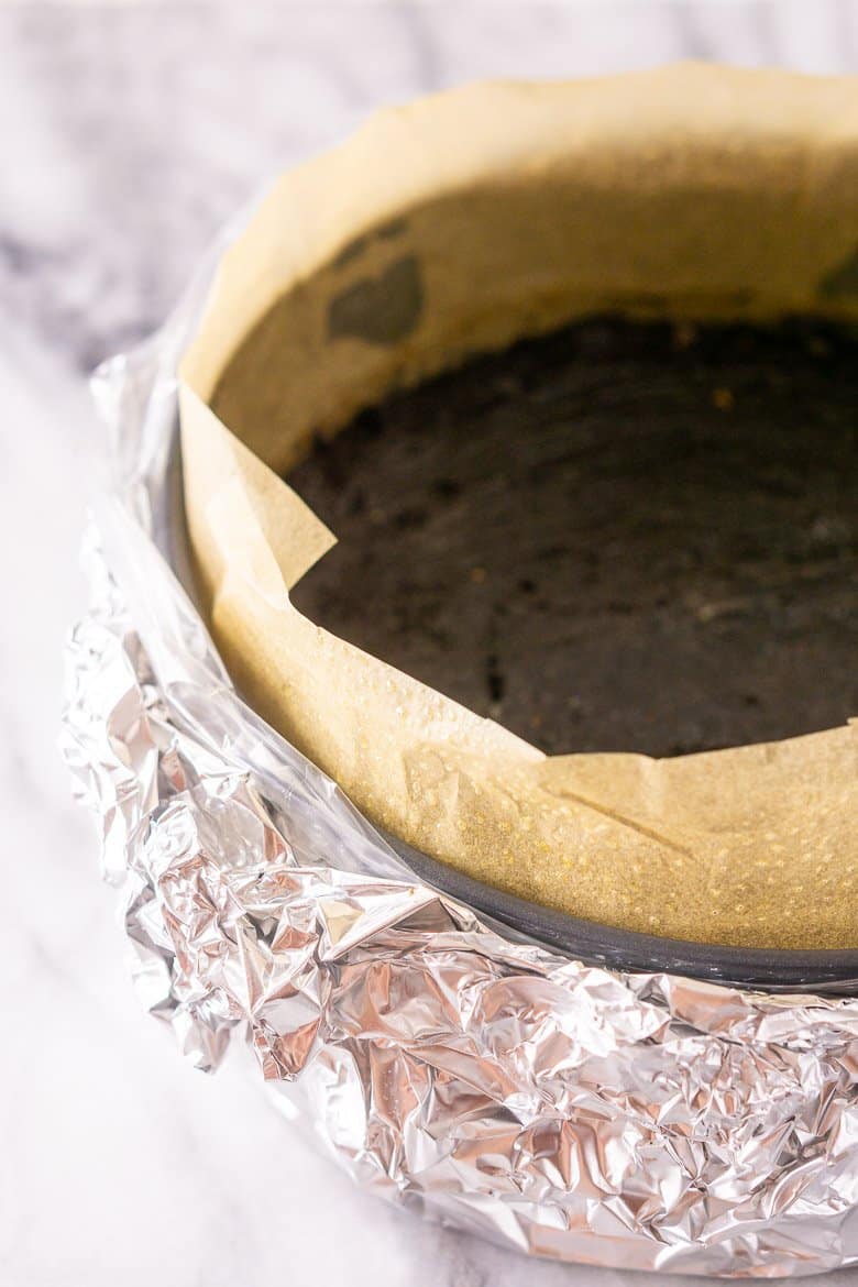 A springform pan wrapped in an oven bag with foil.