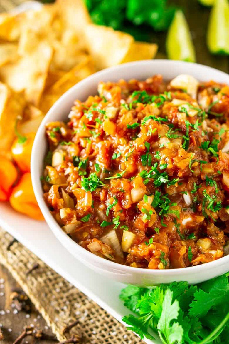 A bowl of Jamaican jerk salsa with ingredients surrounding it.