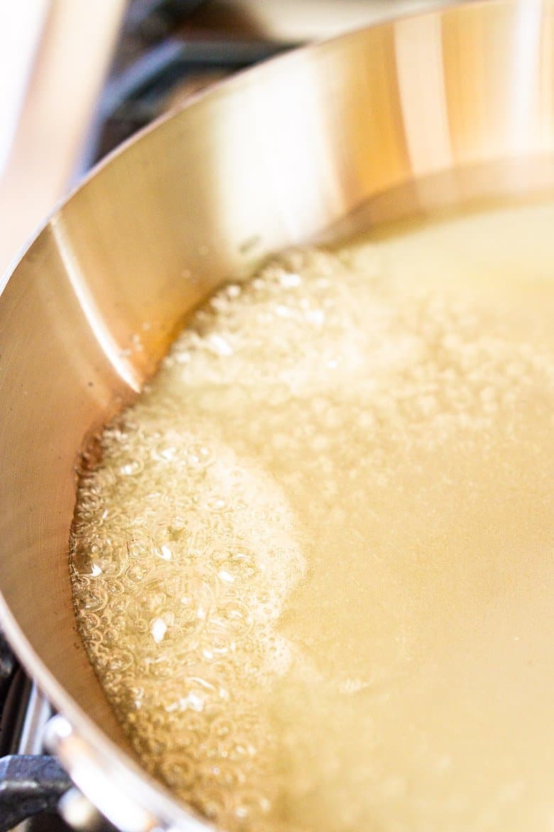 The sugar and water in a pan starting to simmer.