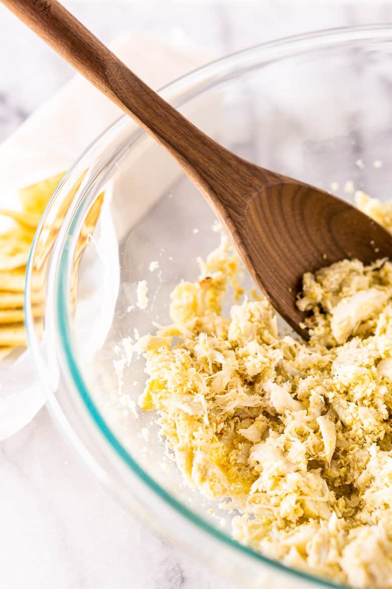 Mixing crushed saltine crackers with crab meat.