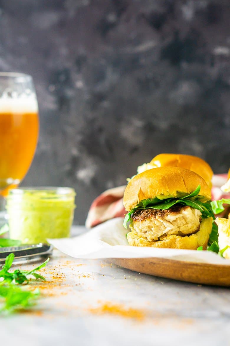A front view of a crab cake slider with Old Bay seasoning and a beer.