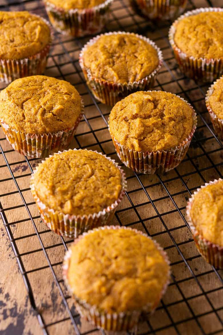 The baked brown butter-pumpkin cupcakes cooling on a wire rack.