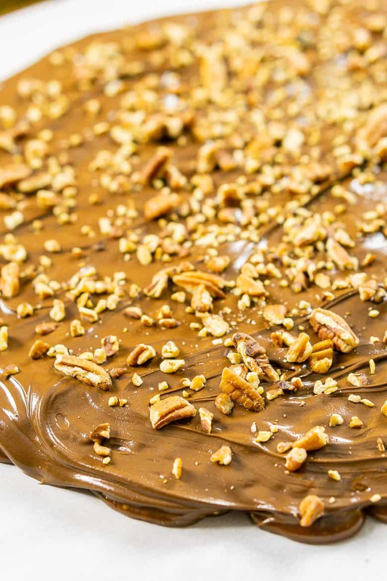 Sprinkling the chopped pecans onto the gingerbread toffee.