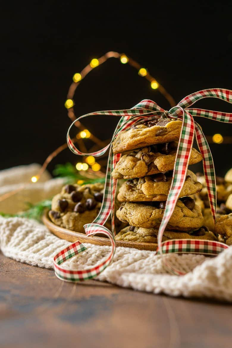 Looking straight on to a stack of spiced holiday chocolate chip cookies with a Christmas.