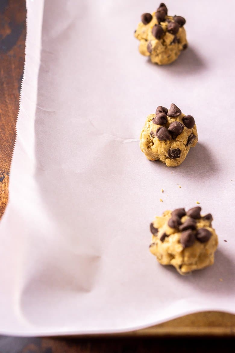 A baking sheet with three balls of cookie dough.