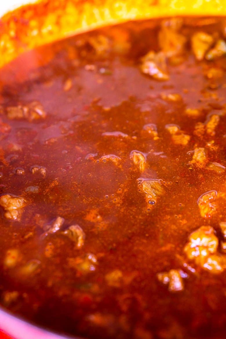 The chili simmering in a large Dutch oven.