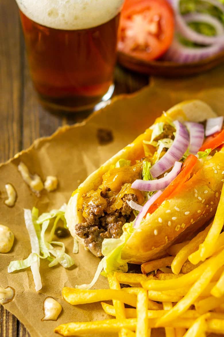 Looking down on a cheeseburger sub with fries and splatters of the special sauce.