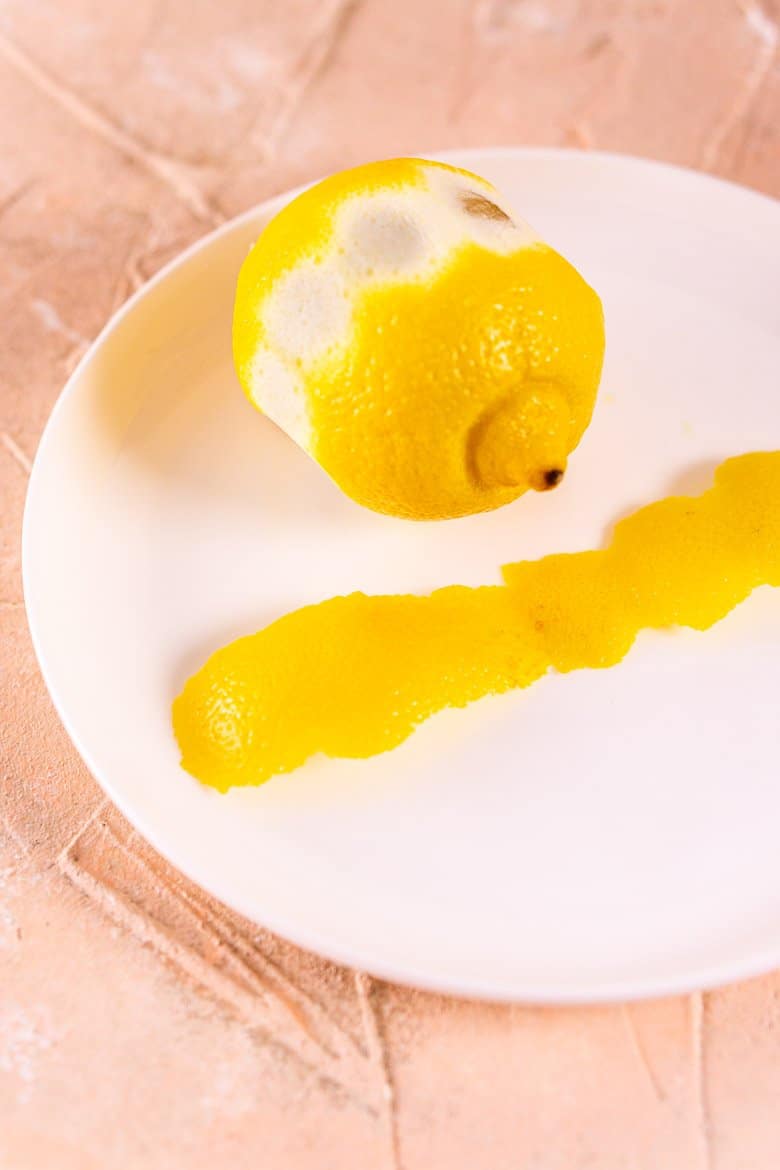 Cutting the lemon peel to make a lemon twist.