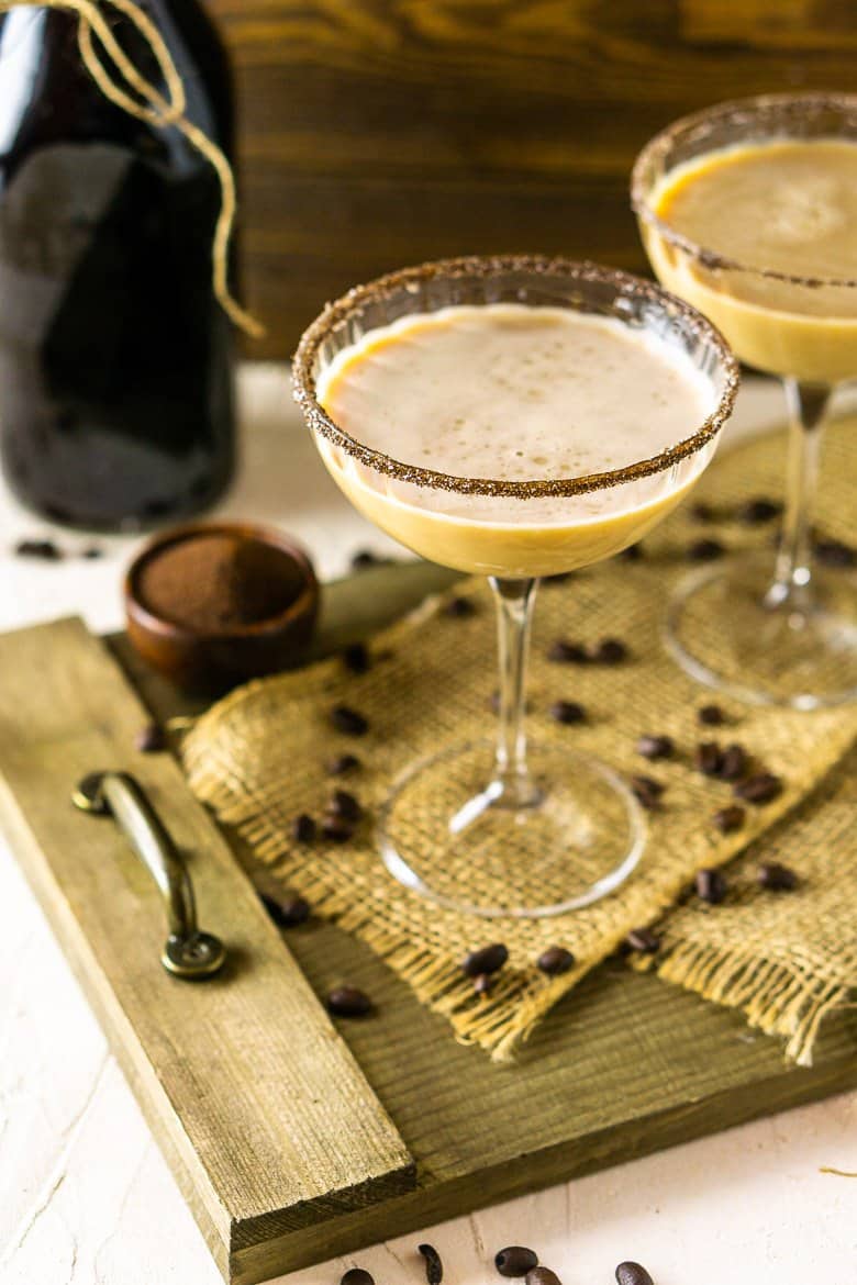 Two Irish coffee martinis on a wooden platter.