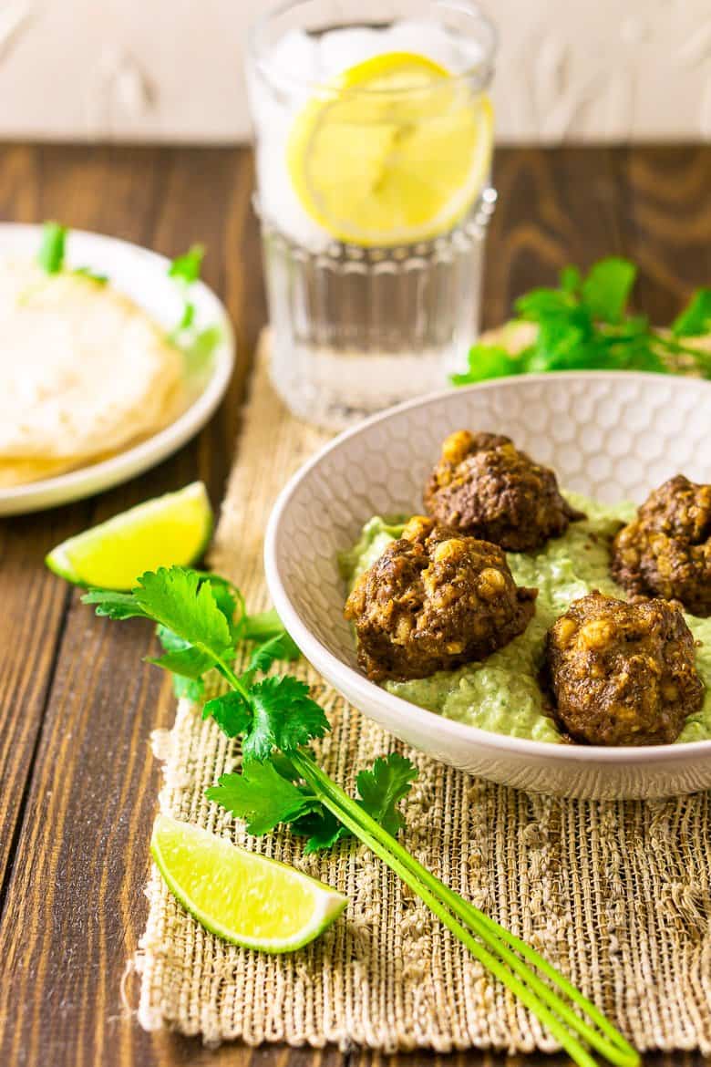 The Mexican meatballs with a lemon water on a placemat.