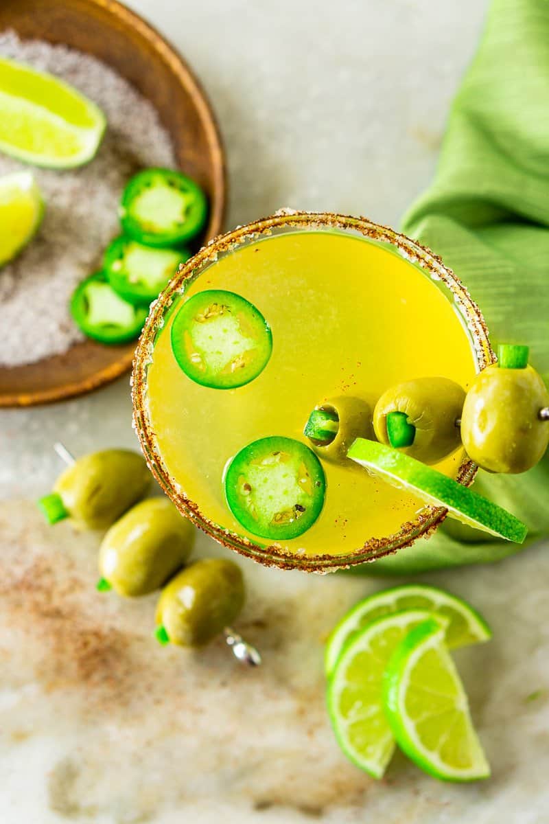 An aerial view of a Mexican martini with a plate of salt and limes.