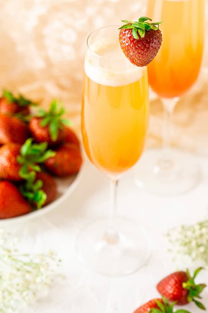 A close-up of a strawberry-rhubarb mimosa with flowers and strawberries.