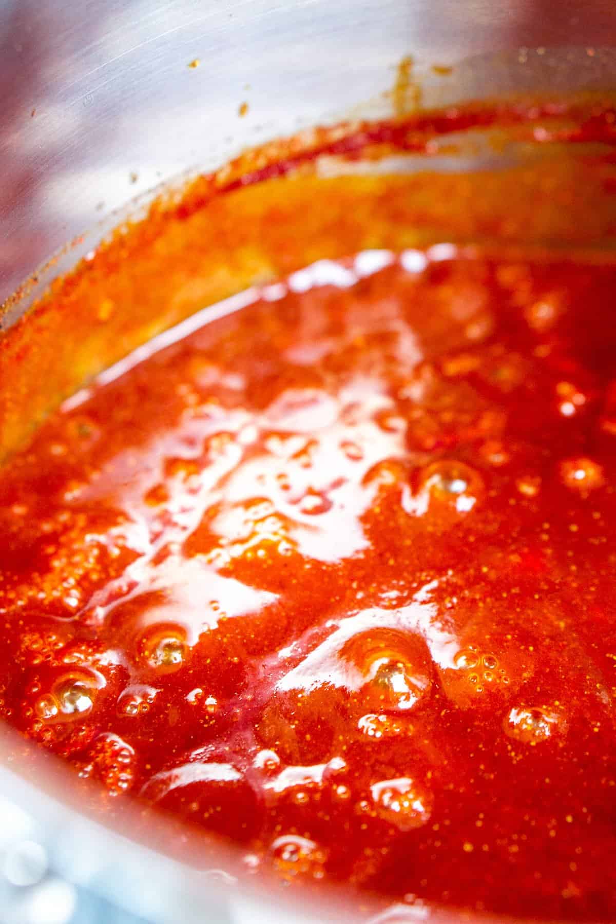 Simmering the sauce until it thickens and the flavors meld in a medium saucepan.