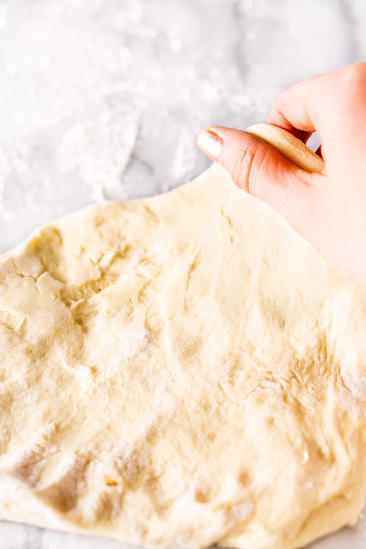 Hand stretching the make-ahead beer pizza dough.