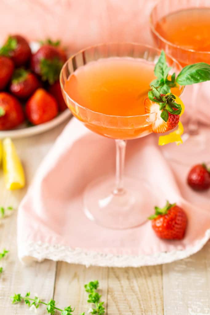 An aerial view of the strawberry-basil martini with fresh basil flowers on the side.